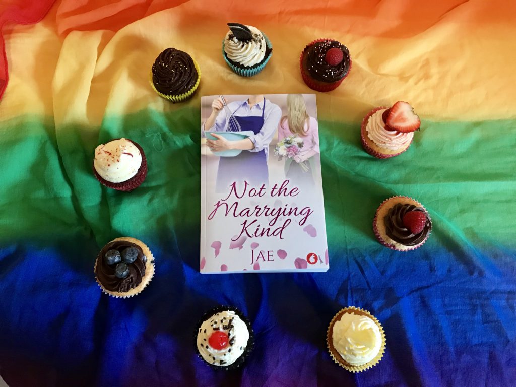 Rainbow of cupcakes with lesbian romance novel by Jae!
